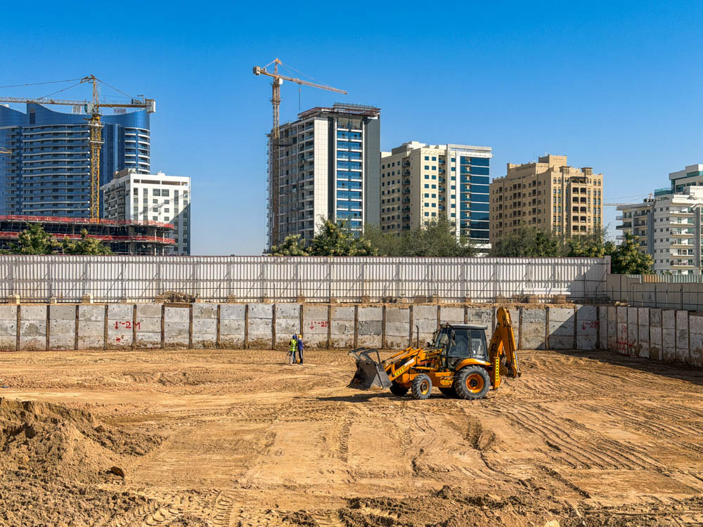 Cove Grand By Imtiaz Excavation site with heavy machinery in the foreground and modern buildings under construction in the background.